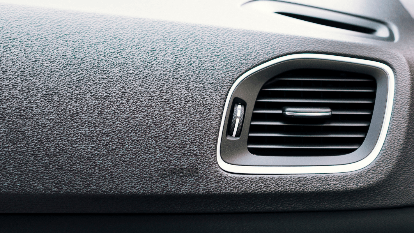 Imagem mostrando o painel do carro com foco na saída de ar condicionado e detalhes do painel de veículos, importante para manutenção automotiva.