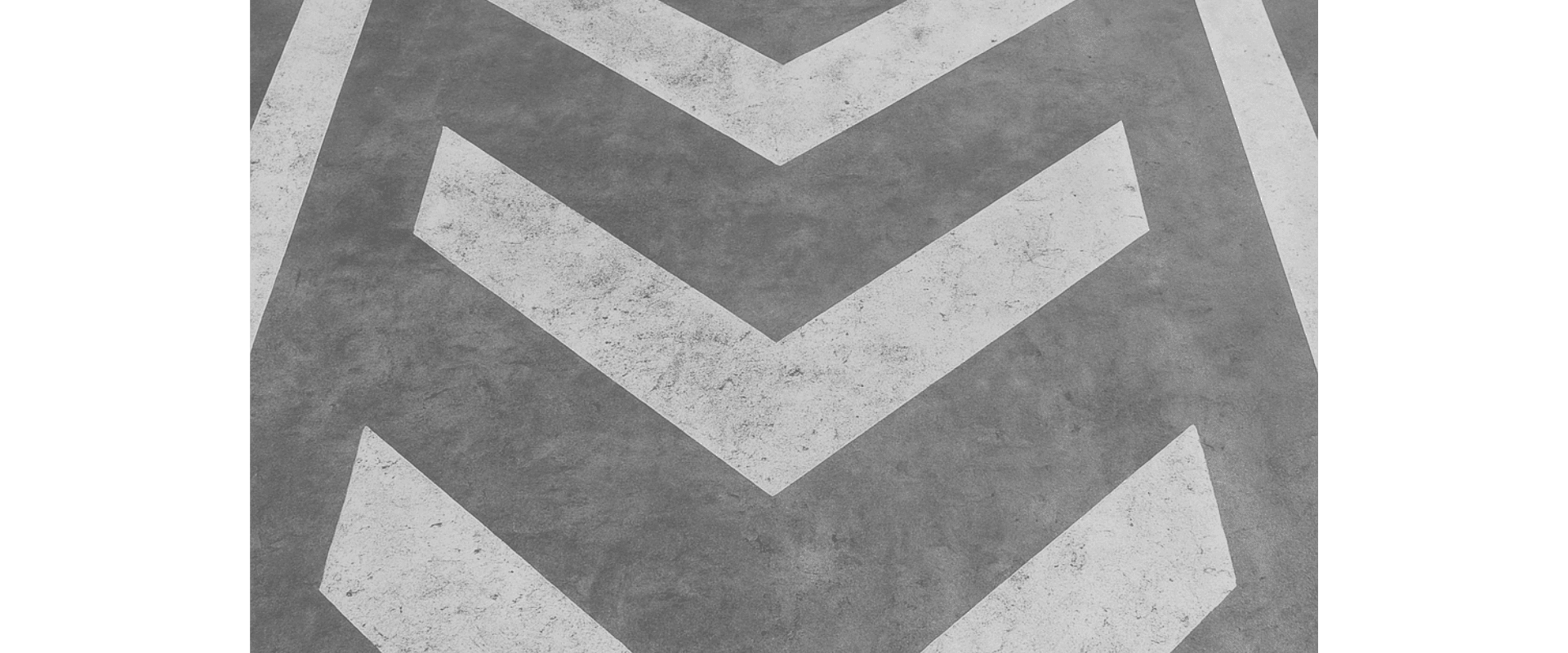 Imagem de marcas de piso com setas em padrão cinza, direcionadas para frente, criando um caminho visual no chão.