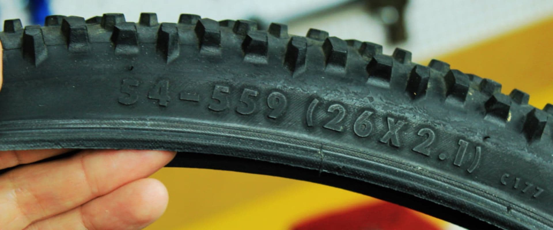 Close-up de um pneu de bicicleta com um adesivo laranja visível na lateral.