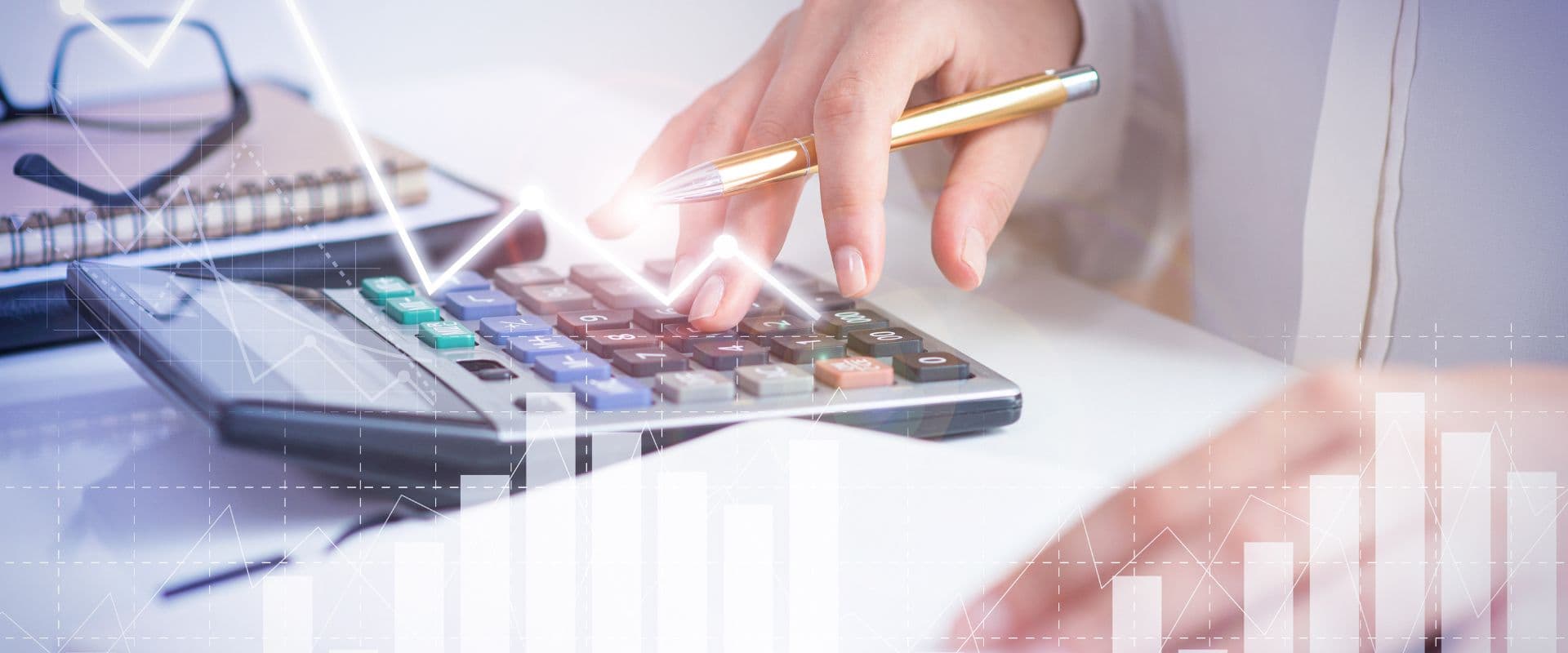 Pessoa usando uma calculadora, realizando cálculos financeiros com gráficos de crescimento ao fundo, destacando análise de dados econômicos.