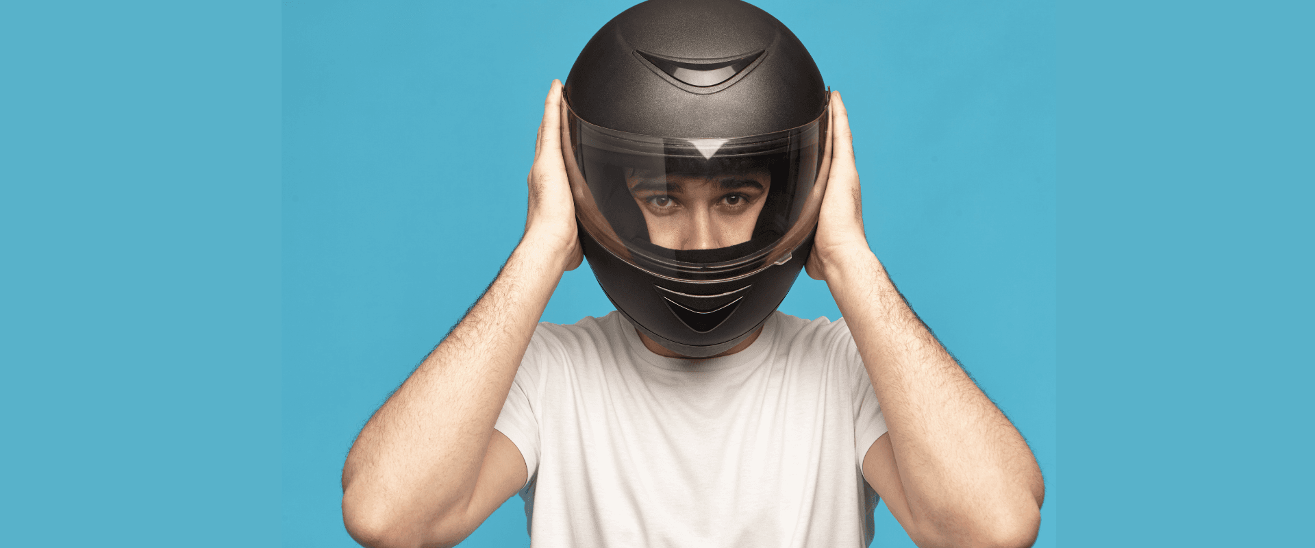 Homem experimentando um capacete para verificar como saber o tamanho do capacete e se a viseira está interferindo na visibilidade