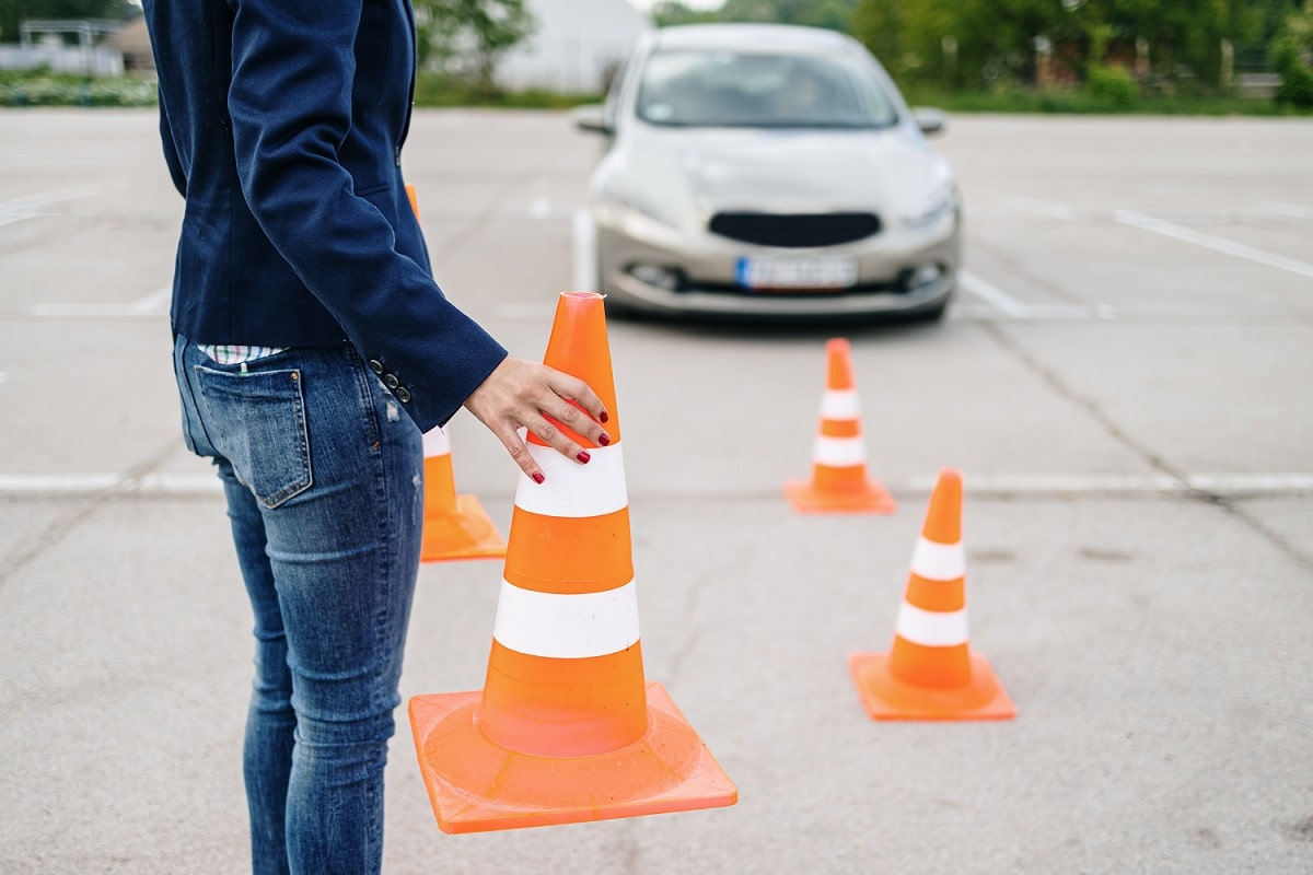 Em primeiro plano, pessoa segura um cone; há outros cones espalhados pelo chão e, ao fundo, um carro estacionado -6 situações que podem ser feitas pelo Detran 