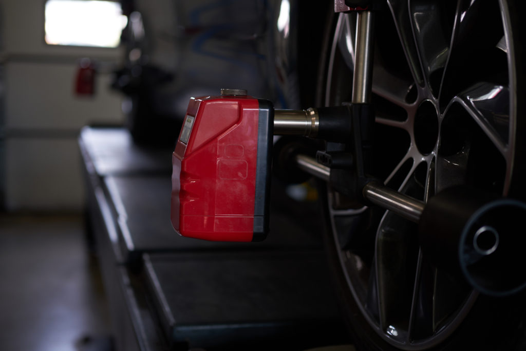 Equipamento de balanceamento da cor vermelha, acoplado em um pneu de carro.